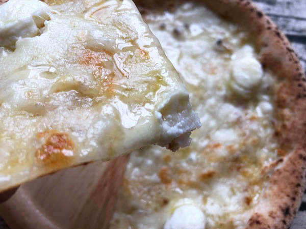 eatime（イータイム）の冷凍ピザ「4種のチーズとはちみつで楽しむクアトロフォルマッジ」にはちみつをかける