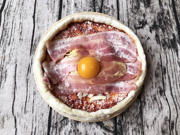 カーサ・カキヤの冷凍ピザ「お肉屋さんの旨ベーコンピザ」に生卵をトッピング