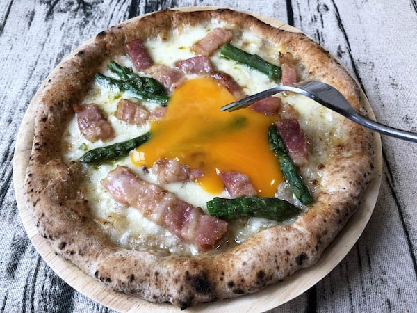 東急ベル「SALUS ONLINE MARKET」の冷凍ピザ「カルボナーラピッツァ」卵黄トッピングを割る