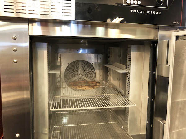 ツジ・キカイの急速冷凍庫「ブラストチラー&ショックフリーザー」に焼き立てのピッツァを投入