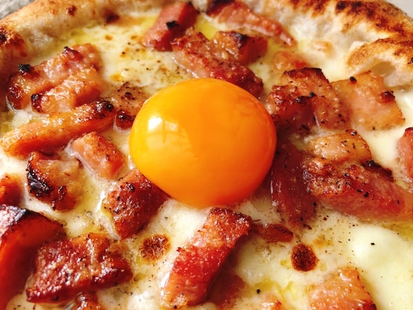 ダ・グランツァの冷凍ピザ「カルボナーラ」にトッピングした卵黄