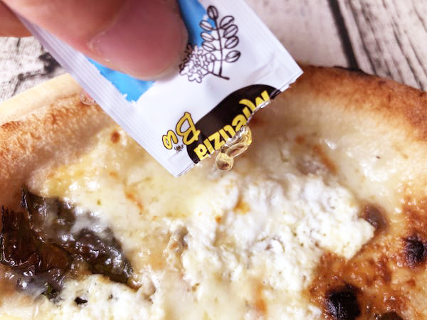 チェザリの冷凍ピザ「匠ピッツァ・クアトロフォルマッジ」に蜂蜜をかける