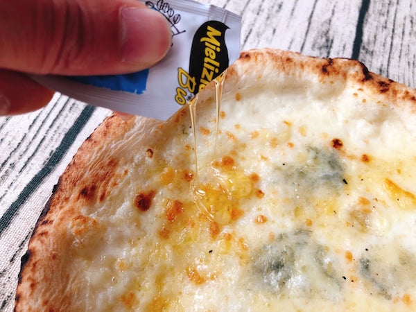 サルヴァトーレカーサの冷凍ピザ「4種のチーズのピッツァ」にミエリツィアのアカシアハチミツをかける